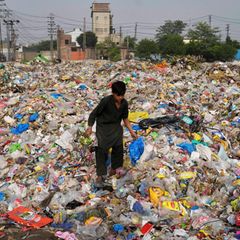 Ein Müllsammler sammelt wiederverwertbare Gegenstände, darunter Plastik, auf einer Mülldeponie