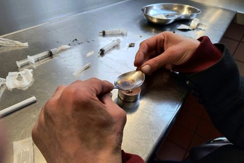 Eine drogenabhängige Frau bereitet sich Heroin vor.
