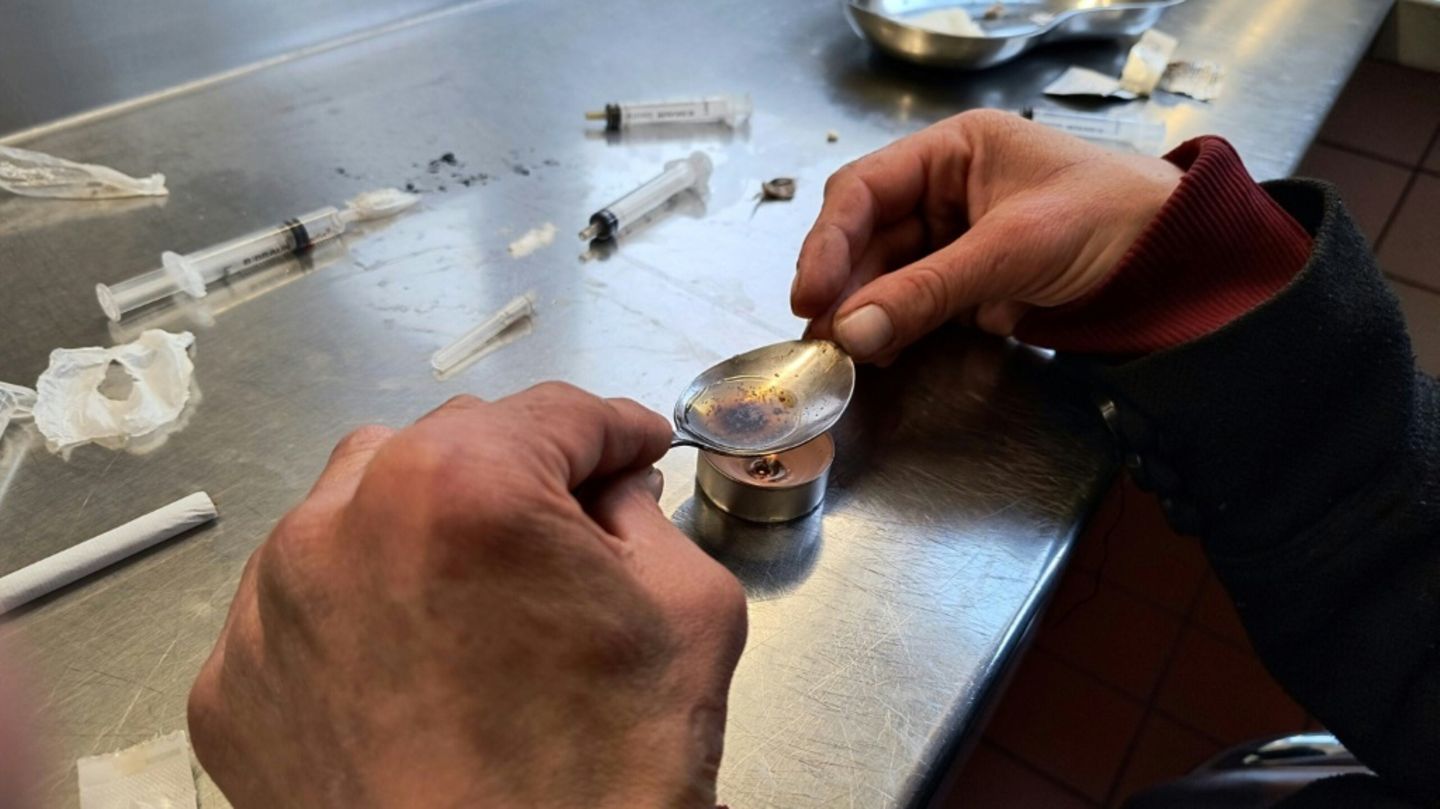 Eine drogenabhängige Frau bereitet sich Heroin vor.