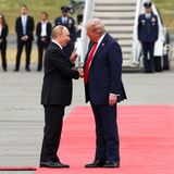 Der erste Kontakt: Wladimir Putin und Donald Trump treffen sich auf dem Rollfeld für einen ersten Handshake
