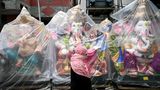 Chennai, Indien. Ein Fußgänger geht kurz vor dem Ganesh Chaturthi-Fest an eingewickelten Statuen der hinduistischen Gottheit Ganesha entlang einer Straße vorbei. Verhüllt sind sie allesamt