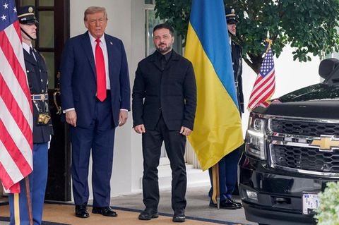 Donald Trump steht neben Wolodymyr Selenskyj zwischen einer US-Fahne und einer Fahne der Ukraine vor dem Weißen Haus