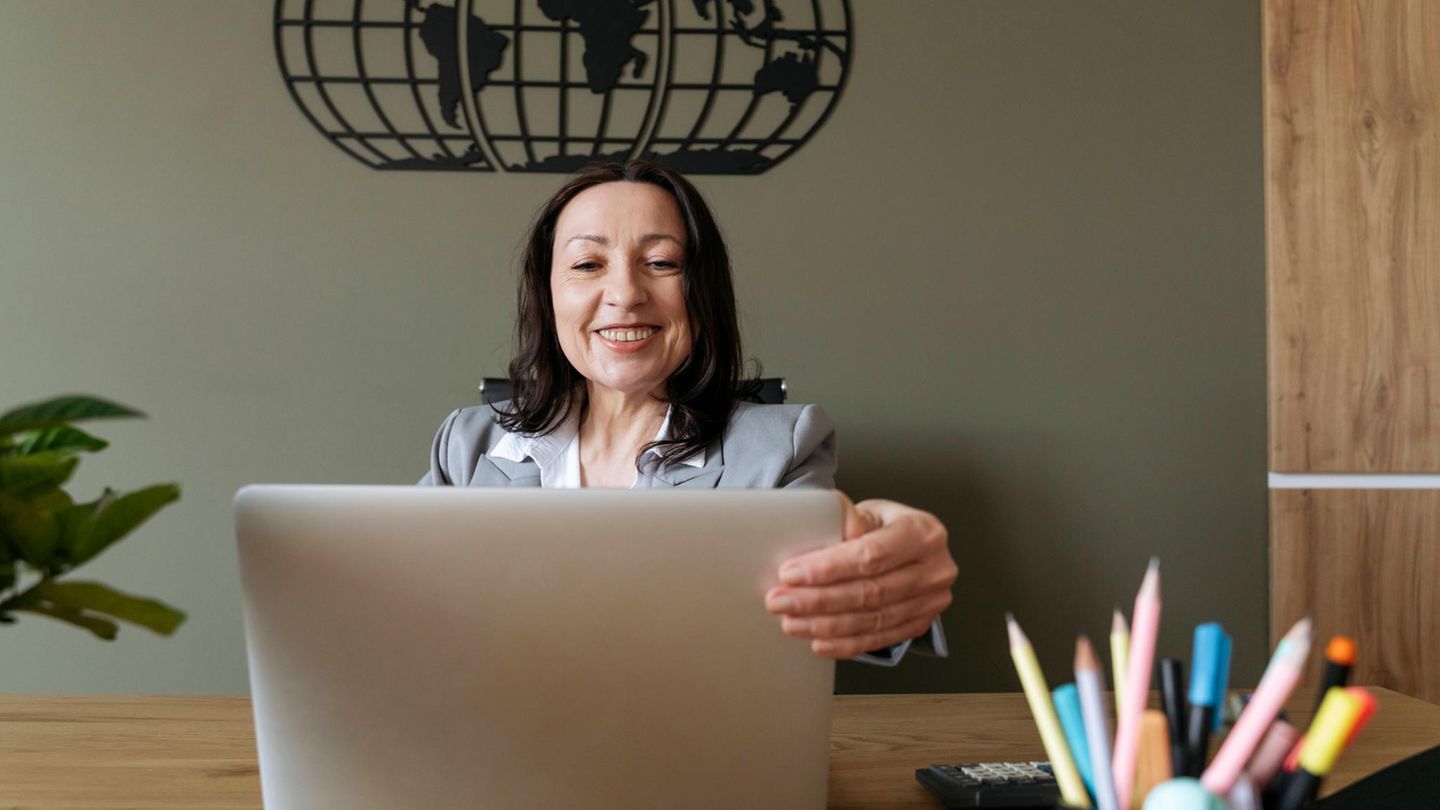 Gehalt: Frau sitzt lächelnd vor einem Laptop