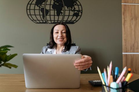 Gehalt: Frau sitzt lächelnd vor einem Laptop