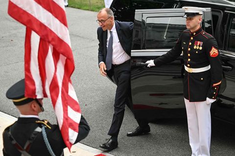 Friedrich Merz steigt aus einem Auto aus, im Vordergrund sind Soldaten und eine amerikanische Flagge zu sehen