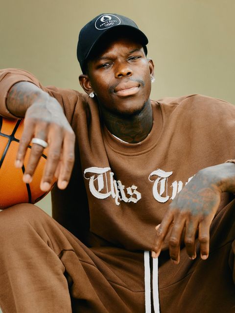 Dennis Schröder sitzt mit Basketball unter dem Arm auf dem Basketballplatz im Prinzenpark