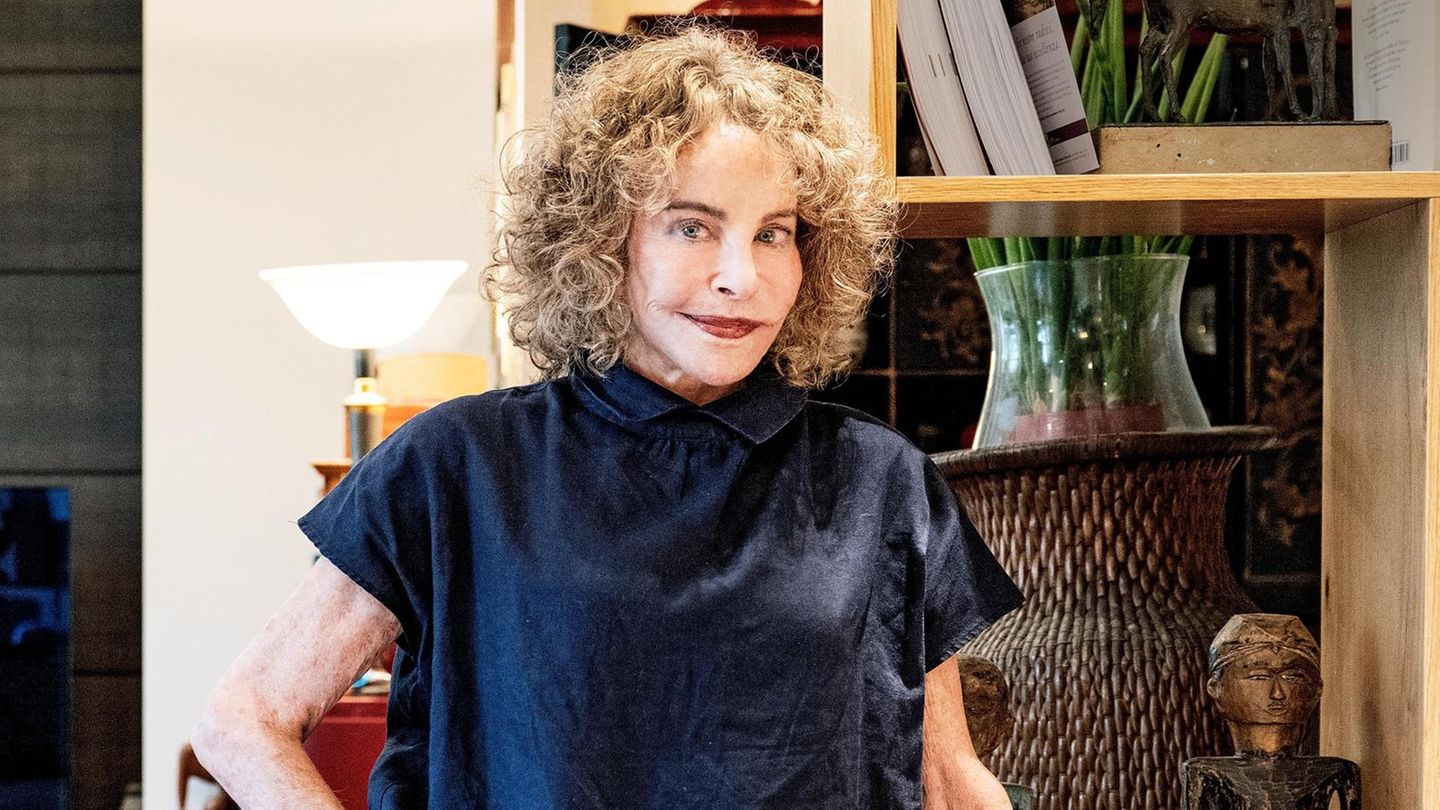 Sydne Rome in ihrer Wohnung in Rom, sie trägt roten Lippenstift und eine blaue Bluse