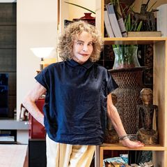 Sydne Rome in ihrer Wohnung in Rom, sie trägt roten Lippenstift und eine blaue Bluse