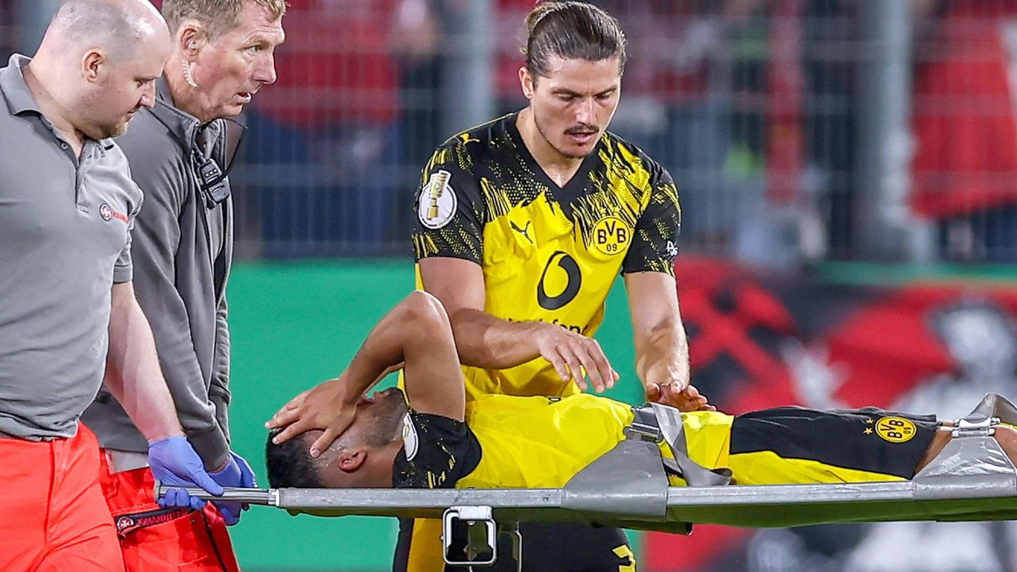 Ein verzweifelter Yan Couto vom BVB hält sie die Hände vor das Gesicht, während er auf einer Trage vom Platz getragen wird