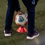 Bundesliga: Ein Ballkind legt einen Fußball auf ein Hütchen