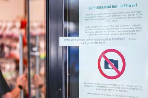 Ein Schild klebt an der Eingangstür eines Geschäfts mit dem "FOTOS verboten" Symbol.