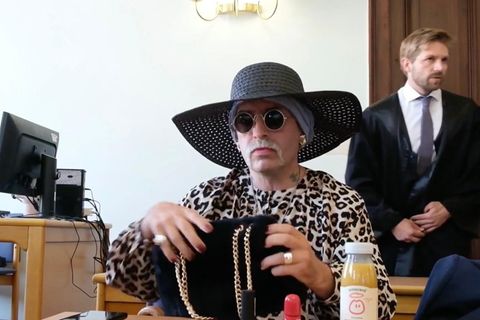 Rechtsextremistin Marla Liebich sitzt mit Hut ud Sonnenbrille im Gerichtssaal.