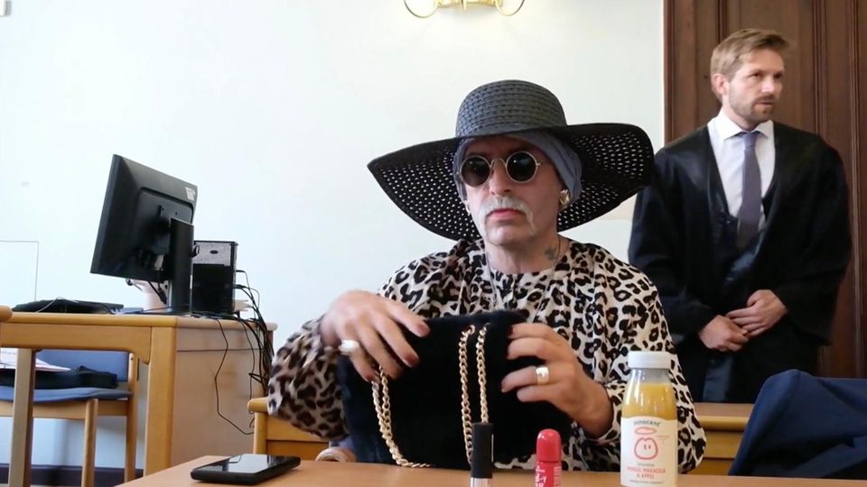 Rechtsextremistin Marla Liebich sitzt mit Hut ud Sonnenbrille im Gerichtssaal.