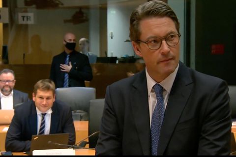 Scheuer steht im Gerichtssaal, im Anzug gekleidet.