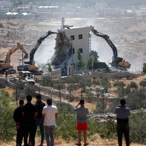Israeli excavators tear off a Palestinian house in southern West Bank