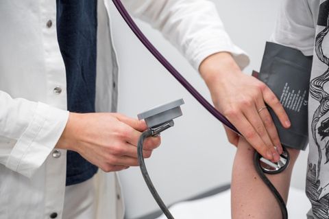 Praxisgebühr: Hausärztin untersucht einen Patienten