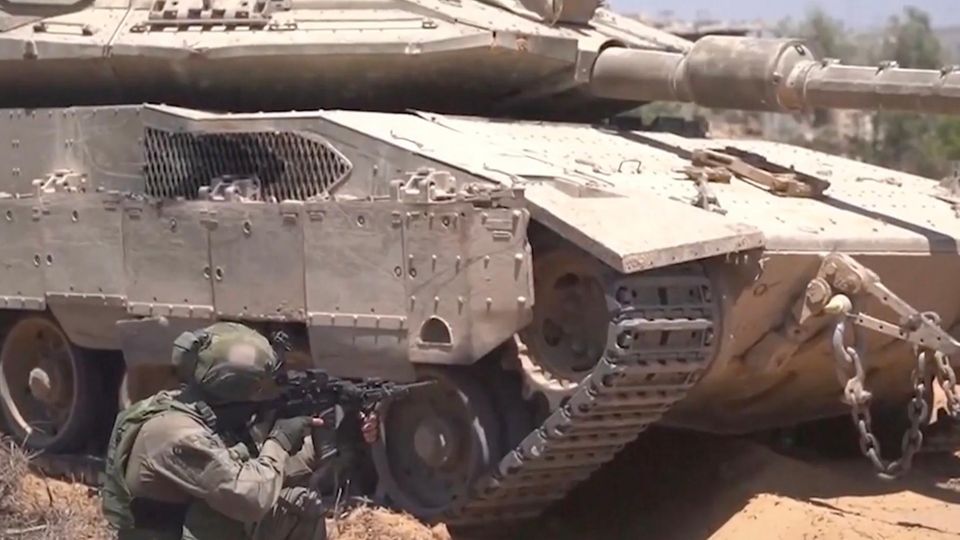 Ein Panzer steht dort, davor kniet ein Soldat