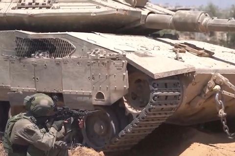 Ein Panzer steht dort, davor kniet ein Soldat