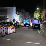 Einsatzfahrzeuge erhellen eine Straße in Völklingen bei Dunkelheit