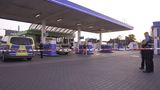 Polizeibeamte untersuchen den Tatort Tankstelle in Völklingen im Saarland