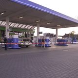 Polizeibeamte untersuchen den Tatort Tankstelle in Völklingen im Saarland