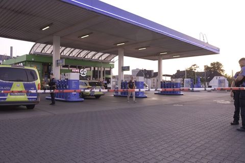 Polizeibeamte untersuchen den Tatort Tankstelle in Völklingen im Saarland