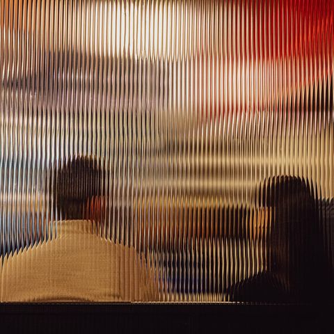 Affair with lawyer A man and a woman sit behind a glass wall (symbolic image of an affair)