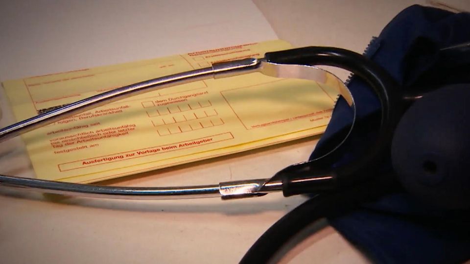 Ein gelber Krankenschein liegt auf dem Tisch mit einem Stethoskop