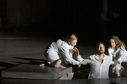 Der Jedermann (Philipp Hochmair) im Juli 2025 in seinem Grab - gehalten vom Glauben (Regine Zimmermann) und seinen Werken (Kathl