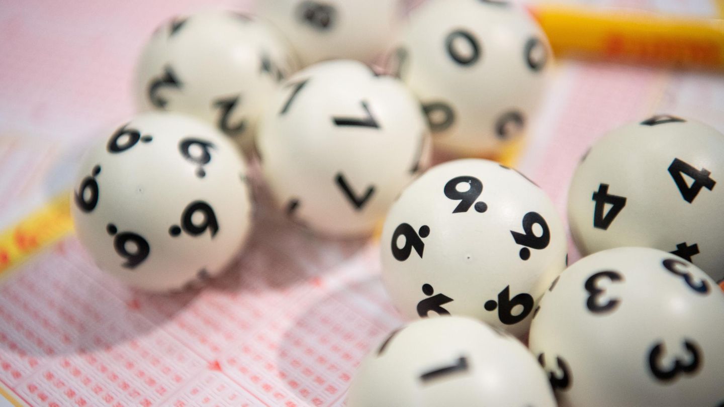 Lottoziehung: Lotto-Kugeln liegen auf einem Lottoschein