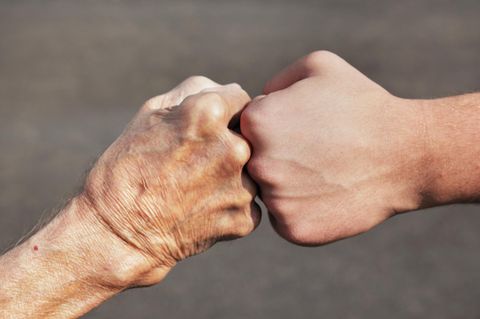 Senior und Junger halten die Fäuste aneinander (Symbolbild Pflichtjahr Senioren)