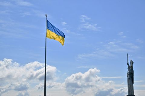 Ukrainische Flagge und Mutter-Heimat-Statue in Kiew