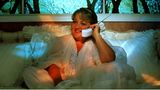 Marianne als Rosalie telefoniert vom Bett aus