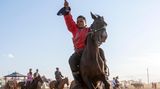 Mongolei: Zuschauer sitzt auf seinem Pferd für bessere Sicht auf das Spektakel