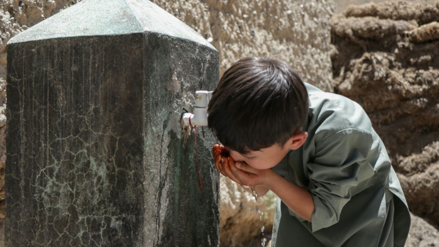 Ein Kind trinkt an einem Wasserhahn