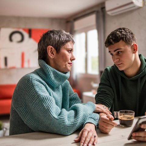 A son sits with the mother in the parents' house