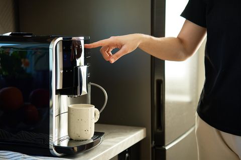 Person bedient Kaffeemaschine