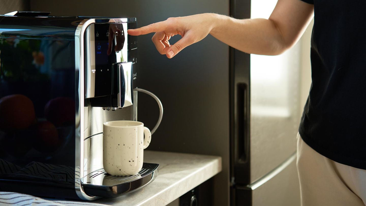 Person bedient Kaffeemaschine