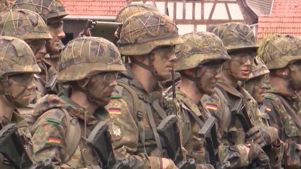 Soldaten der Bundeswehr stehen aufgereit nebeneinander im Tarnmuster-Outfit.