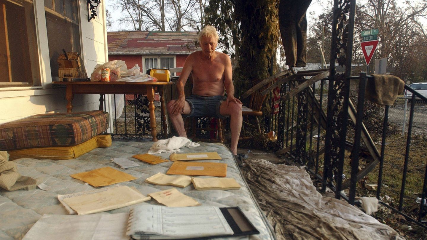 Auf einer Terrasse begutachtet ein Mann seine vorm Sturm geretteten Habseligkeiten: Notizblöcke, Briefe und ein Ordner. Mehr, als viele andere je von ihrem Besitz wiedersehen
