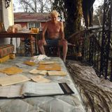 Auf einer Terrasse begutachtet ein Mann seine vorm Sturm geretteten Habseligkeiten: Notizblöcke, Briefe und ein Ordner. Mehr, als viele andere je von ihrem Besitz wiedersehen