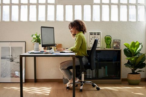Frau sitzt im Homeoffice auf einem Bürostuhl