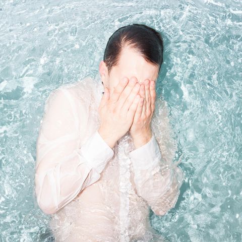 Symbolbild Berufswechsel: Sprung ins kalte Wasser – ein Mann mit weißem Hemd im Wasser