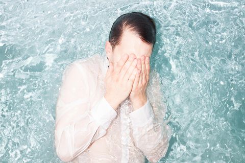 Symbolbild Berufswechsel: Sprung ins kalte Wasser – ein Mann mit weißem Hemd im Wasser