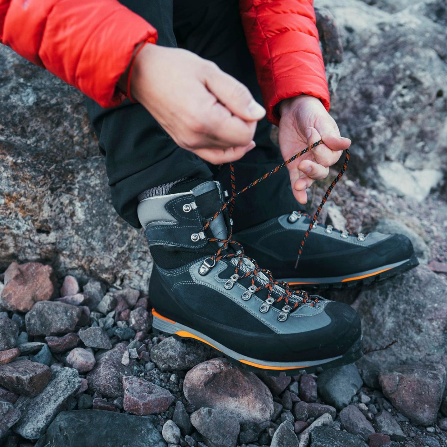 Schuhe fürs Bergsteigen: Mann beim Schuhe schnüren vor einer Wanderung