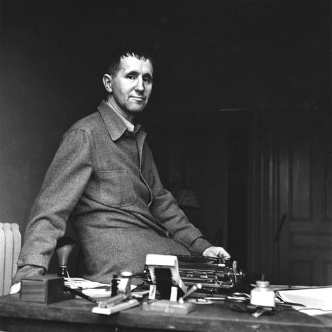A black and white photo of Bertolt Brecht seated on his desk
