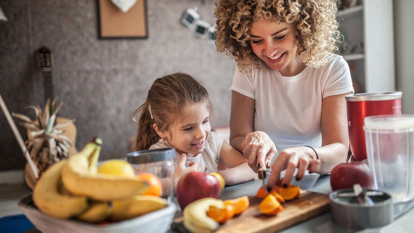 Zwei Kinder schneiden Obst