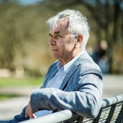 Stressexperte Gert Kaluza sitzt auf einer Bank