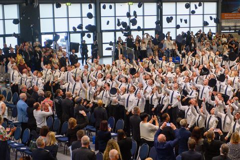 Absolventen der Fachhochschule Polizei Sachsen-Anhalt werfen ihre Dienstmützen in die Luft. Foto: Klaus-Dietmar Gabbert/dpa