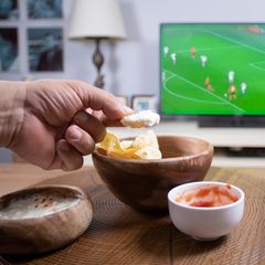 Fußball Snacks: Chips und Dipp auf einem runden braunen Tisch
